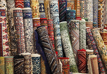 A bunch of rugs rolled up and stacked together